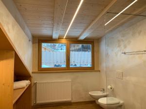 卡纳泽伊Appartamenti Chalet Orchidea的一间带卫生间、水槽和窗户的浴室