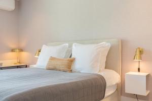 栋堡Hello Zeeland - Summum Suites的一间卧室配有一张带白色枕头的床和两盏灯。
