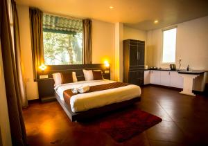 蒙纳Areva Inn Munnar by VOYE HOMES的一间卧室设有一张大床和一个大窗户