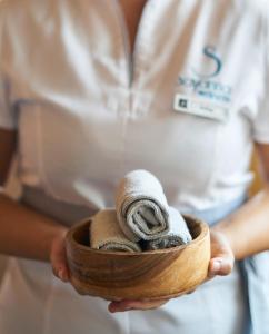 里斯本萨那马尔哈酒店的拿着装满毛巾的木碗的妇女