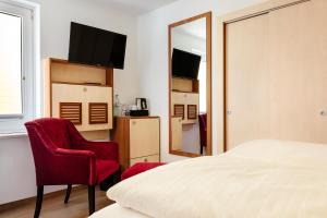 黑尔戈兰岛Helgolandia Dependance的一间卧室配有一张床、两把椅子和镜子