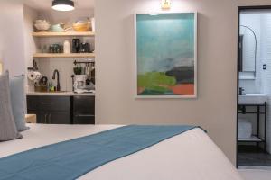 尼格瑞尔旅客海滩度假酒店的卧室配有一张床,墙上挂有绘画作品
