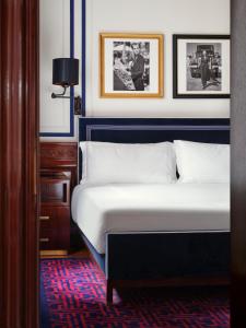 米兰Casa Cipriani Milano的卧室配有一张床,墙上挂有图片