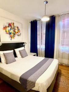 巴约讷Baionakoa Résidence的一间卧室配有一张带蓝色窗帘的大床