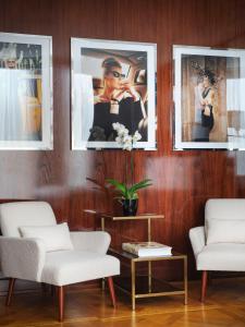 米兰Casa Cipriani Milano的客厅墙上有三幅画