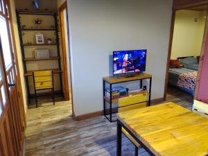埃尔卡拉法特Cabañas Ventalia的一间带桌子和电视的客厅以及一间卧室。