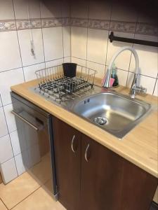 苏瓦乌基Apartament Szpitalna的厨房柜台设有水槽和炉灶。