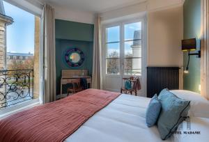波尔多Hôtel Madame的一间卧室设有一张床和一个大窗户