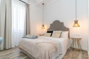 阿莱奥尔Encant de Alaior Boutique Hotel的一间白色卧室,配有两张床和两盏灯。