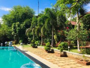 坦加拉鹰巢小屋酒店的一座花园内的游泳池,花园内种有树木,房屋内