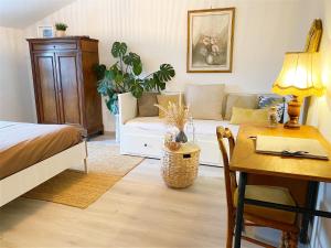 迪塞L'Autre Rivière - Chambres d'hôtes的一间卧室配有一张床、一张桌子和一张沙发
