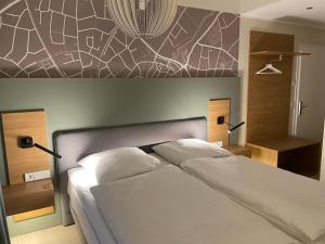 科斯费尔德哈塞尔霍夫酒店及餐厅的卧室配有一张白色床,墙上挂有绘画作品