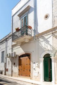 滨海波利尼亚诺WePuglia - Catarì的白色的建筑,设有木门和阳台