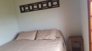 瓜拉雷马Sitio Aconchego Verde Guararema的一间卧室配有一张带枕头和桌子的床