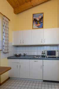 柯尼希斯湖畔舍瑙Waldhauser Hof的厨房配有白色橱柜和微波炉