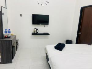 Kampong BembanI-STAY 01 JK Roomstay的酒店客房设有一张床和墙上的电视