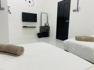 Kampong BembanI-STAY 01 JK Roomstay的白色的客房配有两张床和电视。