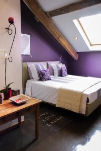 维勒斯第六感酒店的一间卧室设有一张紫色墙壁的大床