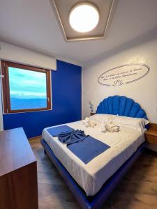 圣马力诺Rainbow Hotel Depandance Joli的蓝色卧室,配有一张大床和蓝色床头板