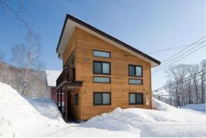 二世古红宝石小木屋的雪中的一个木制建筑,周围积雪环绕