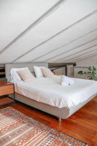 Gilonתניא的一张带白色床单和枕头的床