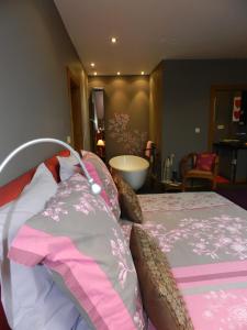 维勒斯第六感酒店的一间卧室配有一张带粉色和灰色床单的床