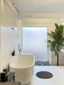 邦拉Chatel BKK的白色的浴室设有浴缸和植物