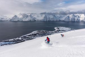 OlderdalenLyngenfjord,Odins Hus的两个人在雪覆盖的斜坡上滑雪