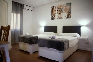 马德里Hostal Ártico的一间卧室设有两张床,墙上挂着一幅画