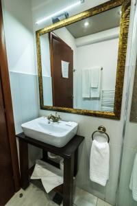 Urziceni皇家酒店的一间带水槽和镜子的浴室