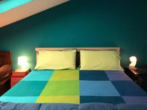 蓬泰代拉Appartamento Alcoba的一间卧室配有一张色彩缤纷的床和两盏灯。