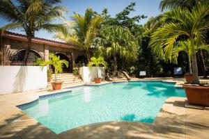 拉利伯塔德Casa Sunzal的一座棕榈树游泳池和一座房子