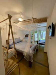 乌巴图巴Bali Suites Itamambuca的一间卧室配有一张带蚊帐的床