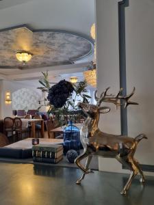 采尔马特Le Mirabeau Resort & Spa的坐在桌子上的一头鹿的铜像