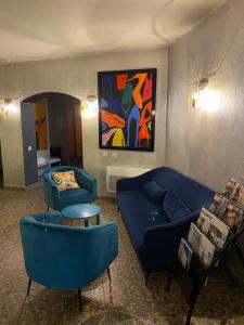 圣康坦法拉维耶拉罗斯利尔酒店的客厅配有蓝色的沙发和绘画作品