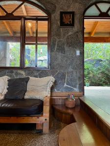 San Lucas TolimánCasa Qatzij - Guest House, Lake Atitlan的一间配有沙发和石墙的房间