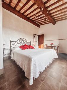 切塔尔多Antica Torre del Borgo的卧室配有带红色枕头的大型白色床