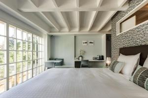 日内瓦日与夜酒店的一间卧室设有一张大床和砖墙