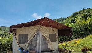 阿纳波伊马Glamping Paraíso Escondido的棕色帐篷,带椅子