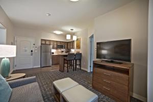 亨博尔Staybridge Suites Houston - Humble Beltway 8 E, an IHG Hotel的带平面电视的客厅和厨房。