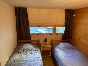 夏蒙尼-勃朗峰Résidence Grand Roc - Bruyères 20的小型客房 - 带2张床和窗户