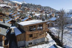 美贝尔Chalet Amis - Meribel - Pool moovie and play room的雪覆盖的村庄中的木屋