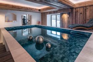 美贝尔Chalet Amis - Meribel - Pool moovie and play room的房屋中间的无边游泳池