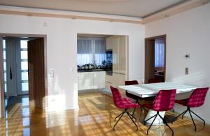 杰尔Dream Apartman 1 with Free Parking的一间设有白色桌子和红色椅子的用餐室