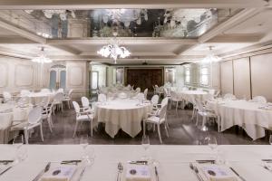 亚历山德里亚阿利杜尔布伊罗西酒店的一间设有白色桌椅的用餐室