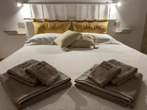 图里Casa Mariù的一张带毛巾和枕头的白色床