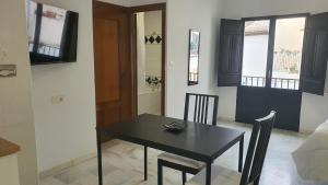 格拉纳达CASA MORENA MiA APARTAMENTOS的一间用餐室,配有黑色的桌子和椅子