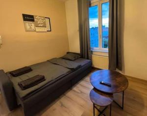 布鲁塞尔Cosy Apartment Merode 2的一间卧室配有一张床、一张桌子和一个窗户。