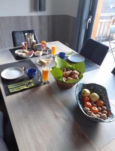 奥瑞斯Chalet de l'Infernet的一张桌子,上面放着食物和饮料,还有一碗水果