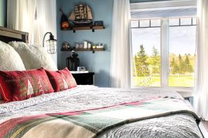MembertouBack Home Bed and Breakfast的一间卧室配有一张带红色枕头的床和一扇窗户